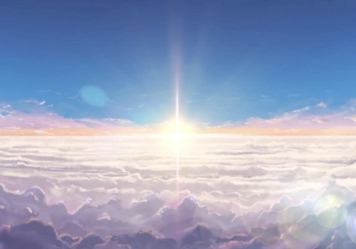 The sun rises over the clouds and a blue sky.  The image seems to be taken from an airplane.